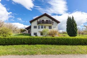 a white house with a balcony on a lawn at Kirschenhof in Bad Bellingen