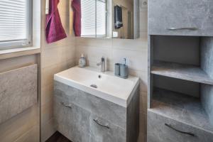 a bathroom with a sink and a mirror at Ferienhaus Bornwiese in Schwalmtal +20 photos
