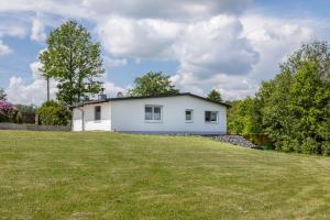 a white house on top of a grassy field at Ferienhaus Bornwiese in Schwalmtal