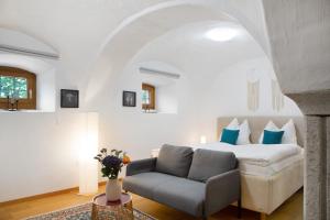 a bedroom with a bed and a couch and a chair at Schönauer Hof - Wohnung Paula in Passau