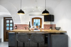 a kitchen with a counter with three chairs in it at Schönauer Hof - Wohnung Paula in Passau