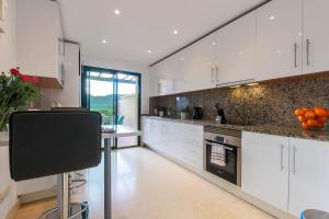 a kitchen with white cabinets and a counter with oranges on it at 2-bed apt in Capanes del Golf in Benahavís
