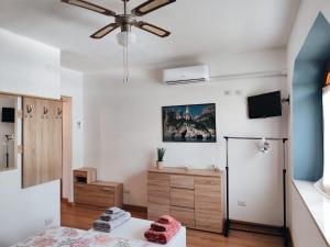 a living room with a ceiling fan and a dresser at B&B Relax Gonone in Cala Gonone