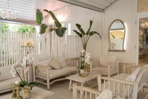 a living room with white furniture and a mirror at Hotel Continental in Pietra Ligure