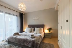 a bedroom with a bed and a large window at 2-bed apt in Capanes del Golf in Benahavís