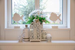 a window sill with a vase of flowers and birds at Hotel Continental in Pietra Ligure