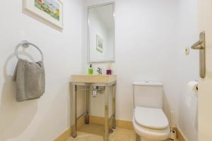 a bathroom with a toilet and a sink and a mirror at 2-bed apt in Capanes del Golf in Benahavís +15 photos