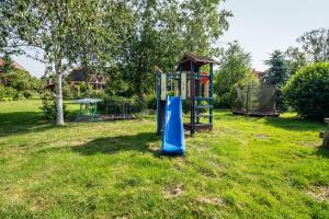 a playground in a grassy yard with a slide at Ferienwohnung 2 Schulze in Neustrelitz