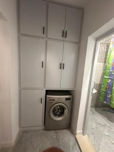 a washing machine in a room with white cabinets at Appartement melita aéroport in Mellita