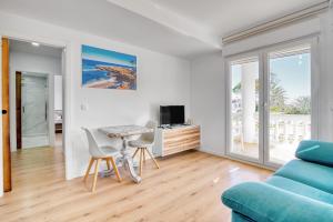 a living room with a couch and a table and chairs at Kuko Beach Denia in Denia