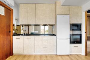 a kitchen with white cabinets and a stove at Kuko Beach Denia in Denia