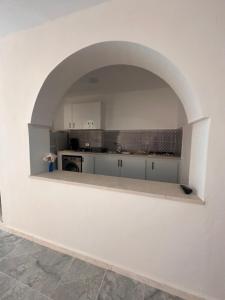 a white kitchen with an arch in the middle at Appartement melita aéroport in Mellita