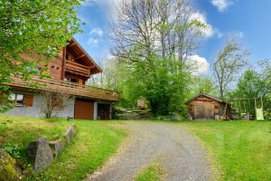 a house with a gravel road next to a barn at Chalet Du Wason in Xonrupt-Longemer