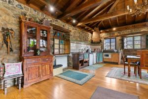 a kitchen with stone walls and a wooden ceiling at La Casa De La Torre in Dosango