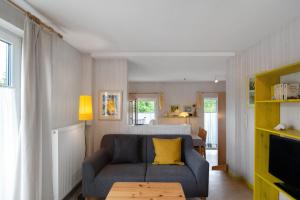 a living room with a blue couch and a table at Möve Aba Bungalow 65 in Rerik