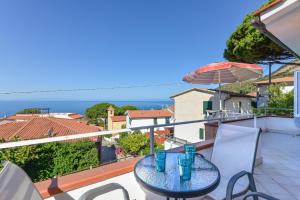 a table on a balcony with a view of the ocean at Appartamento con vista mare Chiessi in Chiessi