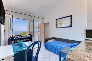 a living room with a bed and a room with a view at Appartamento con vista mare Chiessi in Chiessi