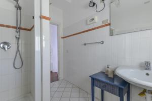 a bathroom with a sink and a shower at Appartamento con vista mare Chiessi in Chiessi +15 photos