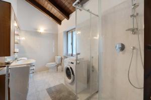 a bathroom with a washing machine and a shower at La mansarda di Mariuccia in Castelletto sopra Ticino +22 photos