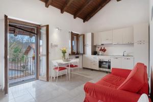 a living room with a red couch and a kitchen at La mansarda di Mariuccia in Castelletto sopra Ticino