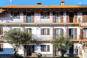a building with balconies and trees in front of it at La mansarda di Mariuccia in Castelletto sopra Ticino
