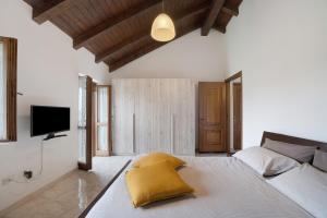 a bedroom with a bed with a yellow pillow on it at La mansarda di Mariuccia in Castelletto sopra Ticino