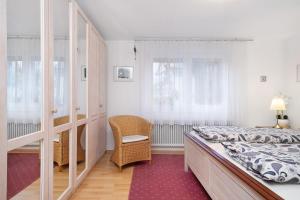 a bedroom with a bed and a chair at Ferienwohnungen Michael u Christine in Langenargen
