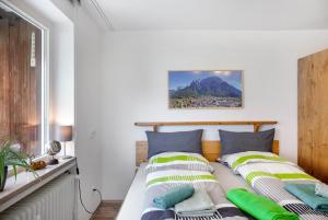 a bedroom with a bed with green and white pillows at Apartment Biendl in Mittenwald