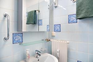 a blue tiled bathroom with a sink and a mirror at Apartment Biendl in Mittenwald +13 photos