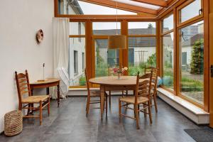 a dining room with a table and chairs and windows at Vierseitenhof mit Pool in Ziesar