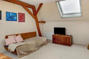 a bedroom with a bed and a flat screen tv at Vierseitenhof mit Pool in Ziesar