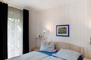 a bedroom with a bed with blue sheets and a window at Möve Aba Bungalow 68 in Rerik