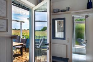 a door leading to a patio with a table and chairs at Möve Aba Bungalow 68 in Rerik