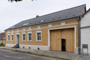 a brick building with a large wooden garage at Vierseitenhof mit Pool in Ziesar