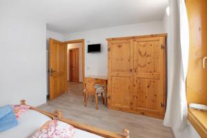 a bedroom with a bed and a wooden cabinet at Appartamento Vacanze Matteo in Livigno