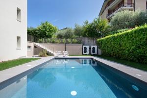 a swimming pool in a yard next to a building at Residence Eleonora in Garda