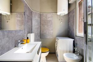 un bagno con lavandino bianco e WC di Dongo Garden a Dongo Altre 16 foto