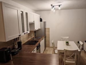 a kitchen with white cabinets and a table and a table and chairs at Apartment Cherry s pogledom na more in Dinjiška