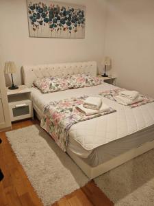 a bed in a bedroom with two night stands and two lamps at Apartment Cherry s pogledom na more in Dinjiška