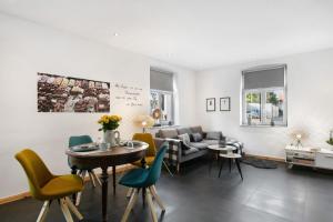 a living room with a couch and a table and chairs at Schöne Altstadtwohnung In Neuruppin in Neuruppin