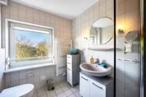a white bathroom with a sink and a mirror at Ferienhof Dethlefsen in Pellworm +93 photos