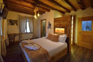 a bedroom with a large bed in a room with wooden ceilings at Affittacamere da Annarè in Comèlico Superiore