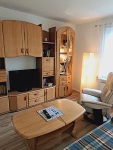 a living room with a tv and a coffee table at Heidtschmidhof Gästehaus in Wolgast