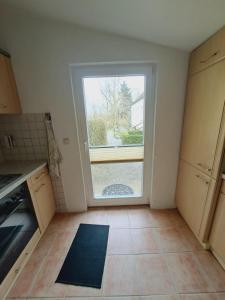 an empty kitchen with a large window in it at Heidtschmidhof Gästehaus in Wolgast +9 photos