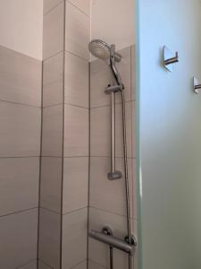 a shower with a shower head in a bathroom at Gästehaus Orchidee in Hoya