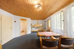 a dining room with a table and chairs and a bedroom at Bungalow 2 - Kimbucht in Reichendorf +16 photos