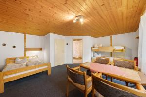 a room with two beds and a table and chairs at Bungalow 2 - Kimbucht in Reichendorf
