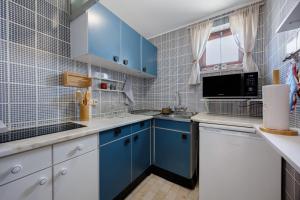 a blue and white kitchen with blue cabinets at Casa Pôr do Sol in Alvor