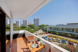 an apartment balcony with a table and a view of a city at Casa Pôr do Sol in Alvor