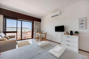 a bedroom with a bed and a television and a table at Casa Pôr do Sol in Alvor